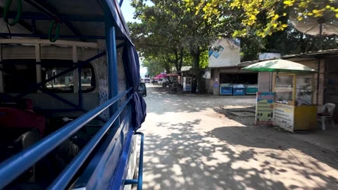 A view from inside a blue taxi driving through the streets of Vang Vieng Laos Stock Footage 325183960