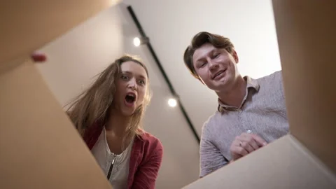 View from inside box couple opening parcel with excited surprised facial Video stock 167563750