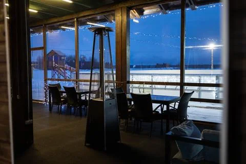 View from inside a cafe lounge with empty tables, looking through windows at an Stock Photos