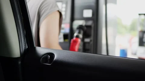 View from inside car of customer paying at gas station pump. Stockbeeldmateriaal 316914152