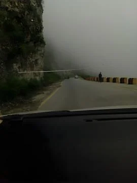A view from inside a car driving on a road with heavy fog Stock Photos