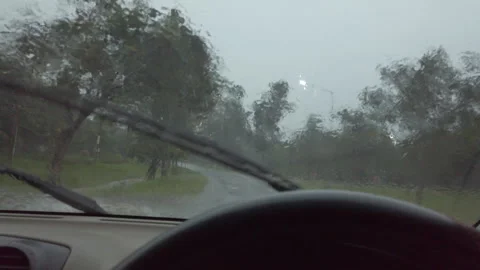 A view from inside a car driving on a wet road during heavy rain. The windshield Stock Footage 323380387
