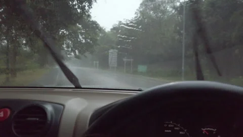 A view from inside a car driving on a wet road during heavy rain. The windshield Stock Footage 323380777