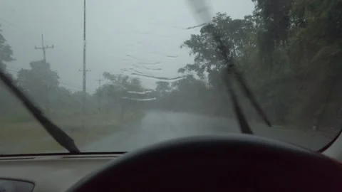 A view from inside a car driving on a wet road during heavy rain. The windshield Stock Footage 323380791