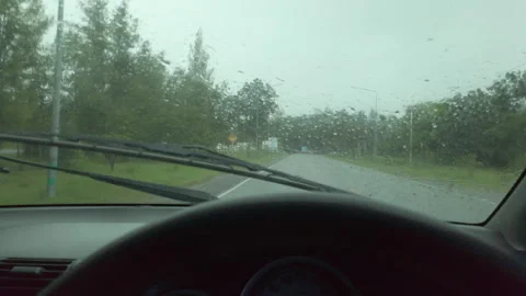 A view from inside a car driving on a wet road during heavy rain. The windshield Stock Footage 323383816