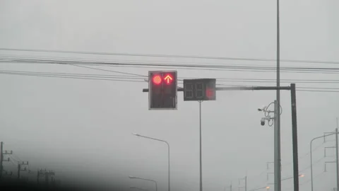 View from inside car parked on road waiting for traffic light turn green in rain Vídeos de archivo 174085794