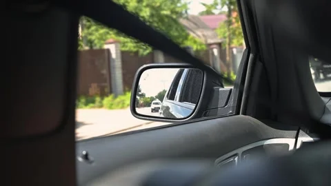 A view from inside a car shows a side mirror displaying reflections of light and Video stock 345868498