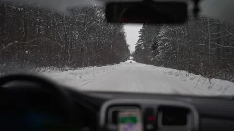 View from inside the car on a snow-covered forest road.  Stock Footage 262677719