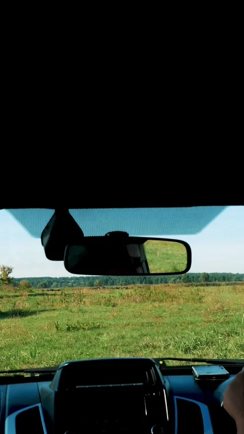 View from inside the car through the windshield. farmer rides through the green Stock Footage 305504724
