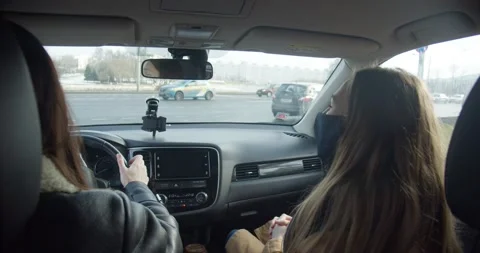 View from inside car, two business women in face masks talk while driving Stock Footage 157196348
