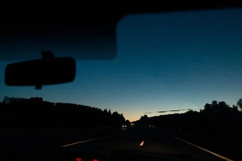 View inside a car while driving at dusk on a road Stock Photos