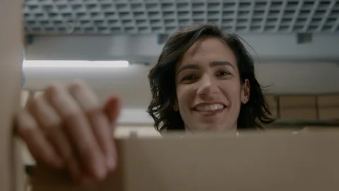 View from Inside Cardboard Package Box: Handsome Warehouse Worker Unboxes Parcel Stock Footage 96025694