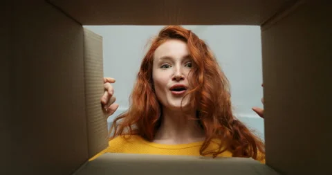 View from inside of cardbox on young cheerful Caucasian woman with red hair who Stock Footage 130224642