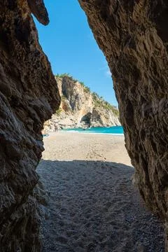 View from inside a cave into the beach Stock-Fotos