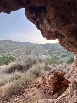 A view from inside of a cave in the mountains Stock Photos