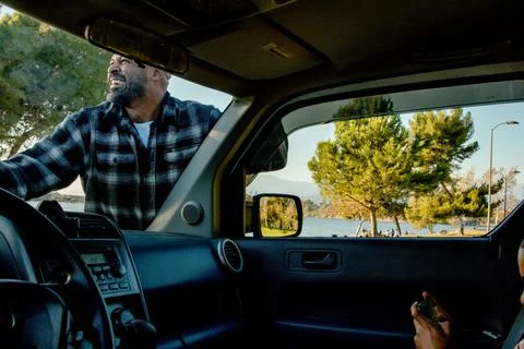 View from inside the driver's seat looking out at dad cleaning the window while Stock Photos