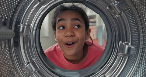 A view from inside the drum, a girl has a new washing machine at home, she looks Vídeo Stock 201244414