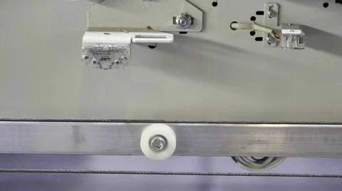 View inside of elevator mechanism with moving stretched metal cable. Media Foto stock
