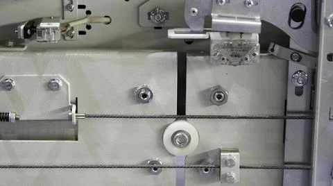 View inside of elevator mechanism with moving stretched metal cable. Media Foto stock
