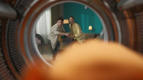 View from inside the empty washing machine young couple with laundry basket Stock Footage 247470183