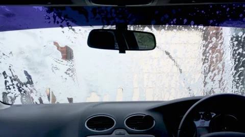 A view from the inside of a Ford Focus while someone soaps up the windscreen Stock Footage 163149588