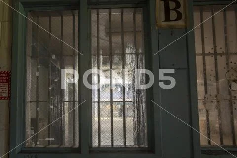 View from inside guard station to prison cellblock Stock Photos