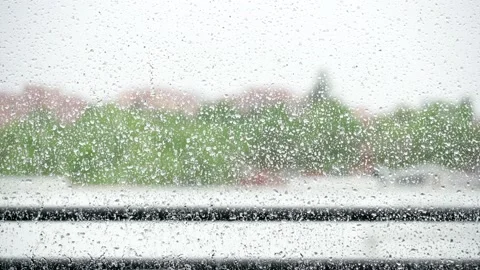 View from inside a house of the detail of raindrops falling on a window on a Stock Footage
