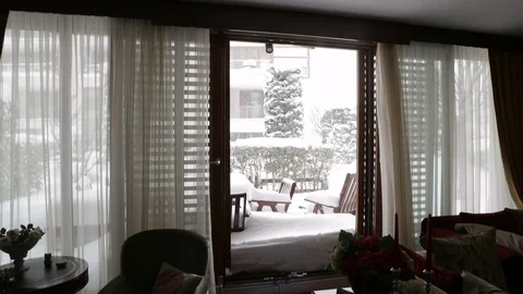 View from inside of a luxury house, windows open and snowing outside. Stock Footage 76759925