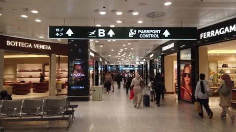 View inside Malpensa Airport duty free shop, people walk around fancy fashion Video stock 312623074
