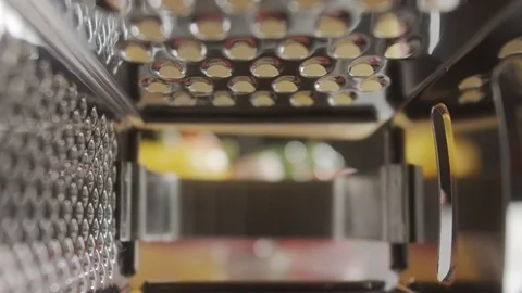 View inside metal grater. Hand rubs cheese on metal grater. Slow motion video Video stock 123100392