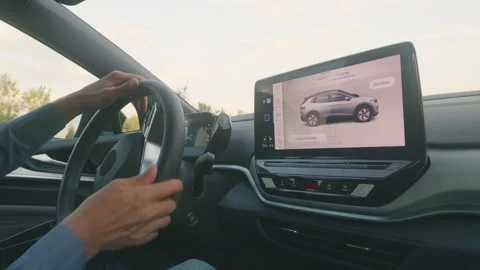 View from inside modern electric vehicle which starts a trip, man drives a car Stock Footage 220493676