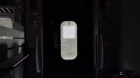 View from inside modern train carriage door window showing blurred green Stock Footage 339866098