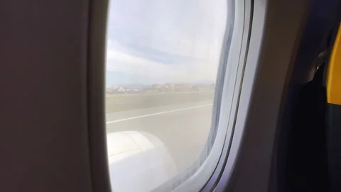 View from inside the moving aircraft through the porthole window on airport Stock Footage 310464111