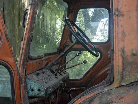 View Inside the old and rusty tractor cab. Abandoned agricultural machinery Stock Photos