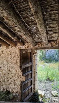 View from inside an old stone barn towards a green summer garden through a .. Fotos Stock