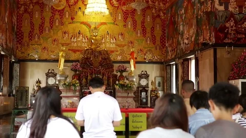View of inside of ornately painted temple and back view of people praying 動画素材 101456275