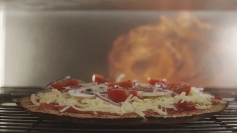View inside the oven. Cooking pizza in the oven with a blazing fire. Slow motion Stock Footage 122997395