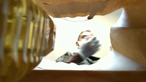 View from inside a paper bag of a military man with mask and gloves stuffing Stock Footage 219735650