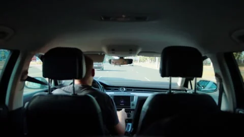 View from inside passenger compartment of vehicle, showing male driver on road 스톡 동영상 339864455
