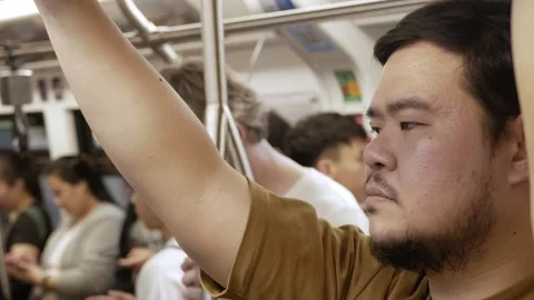 View inside public transportation train commuter while an asian man holding.. Video stock 297454408