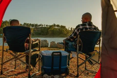View from inside the red camping tent looking out at young son and father Foto stock