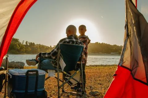 View from inside the red camping tent looking out at young son standing in front Stock Photos