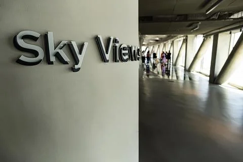 View inside the Sky View skyscraper. Tourists walk on the glass floor and t.. Stock Photos