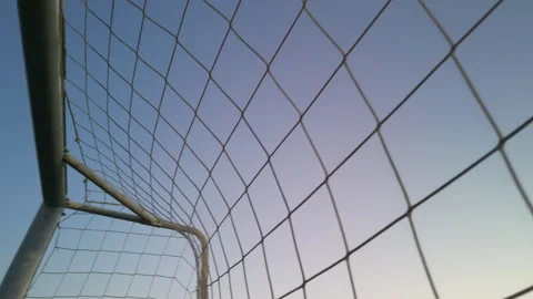 View from inside a soccer goal net against a clear blue sky Stock Footage 340066578