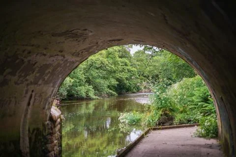 View From Inside Stone Bridge Archway Looking Out To River And Green Foliage Stock Photos