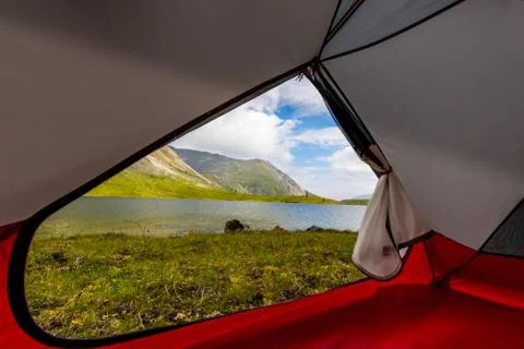 View from inside the tent out of the mountains and lake in the summer Stock Photos
