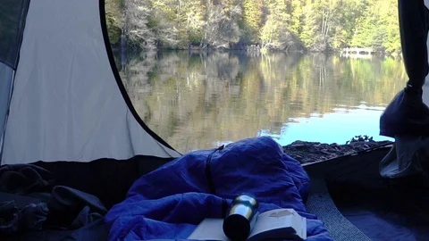 View from inside a tent set by the lake Stock Footage 98509190