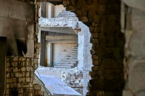 View from inside through the broken wall to the next destroyed building with Stock Photos