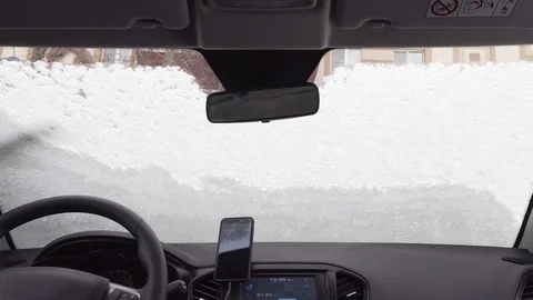 View inside through the windshield of the car - man cleans the car from the snow Stock Footage 104823581