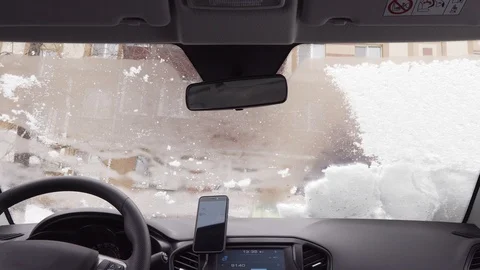 View inside through the windshield of the car - man cleans the car from the snow Vidéo 104823642